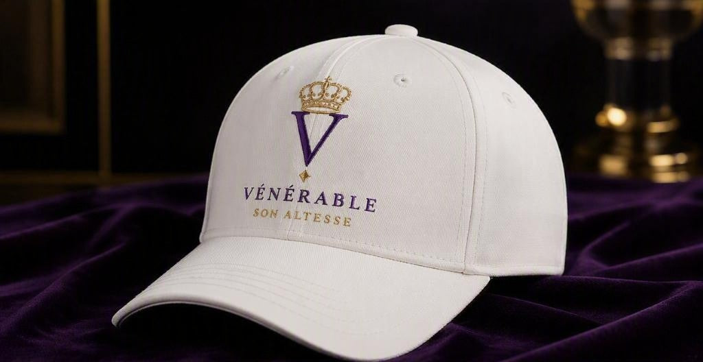 Casquette SON ALTESSE – Blanc Impérial — casquette blanche vue de trois quarts sur velours violet. Maison VÉNÉRABLE.