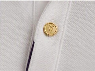 Polo SON ALTESSE – Impérial — bouton doré gravé du monogramme et passepoil violet. Maison VÉNÉRABLE.